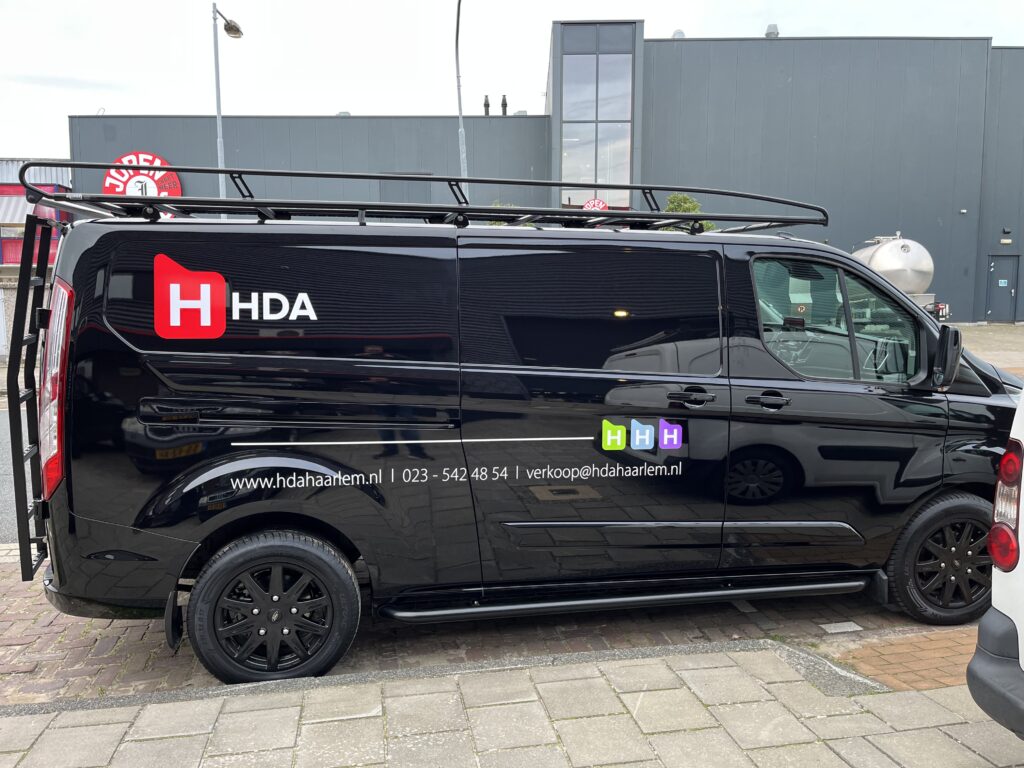 Volledige autobelettering op bedrijfsbus met logo en contactgegevens, uitgevoerd door PlakPower in Noord-Holland