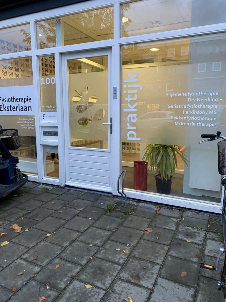 Raambelettering met bedrijfsnaam en openingstijden op etalageruit, aangebracht door PlakPower Haarlem
