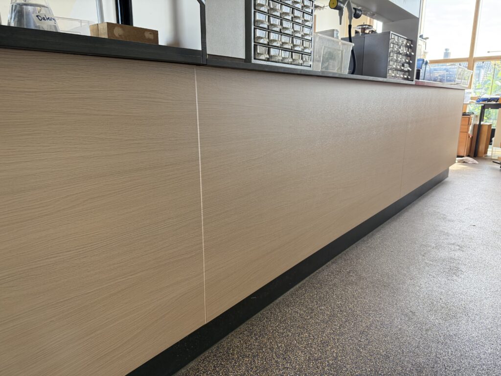 Groot interieurpaneel gewrapt in lichte houtlook bij het Coornhert Lyceum