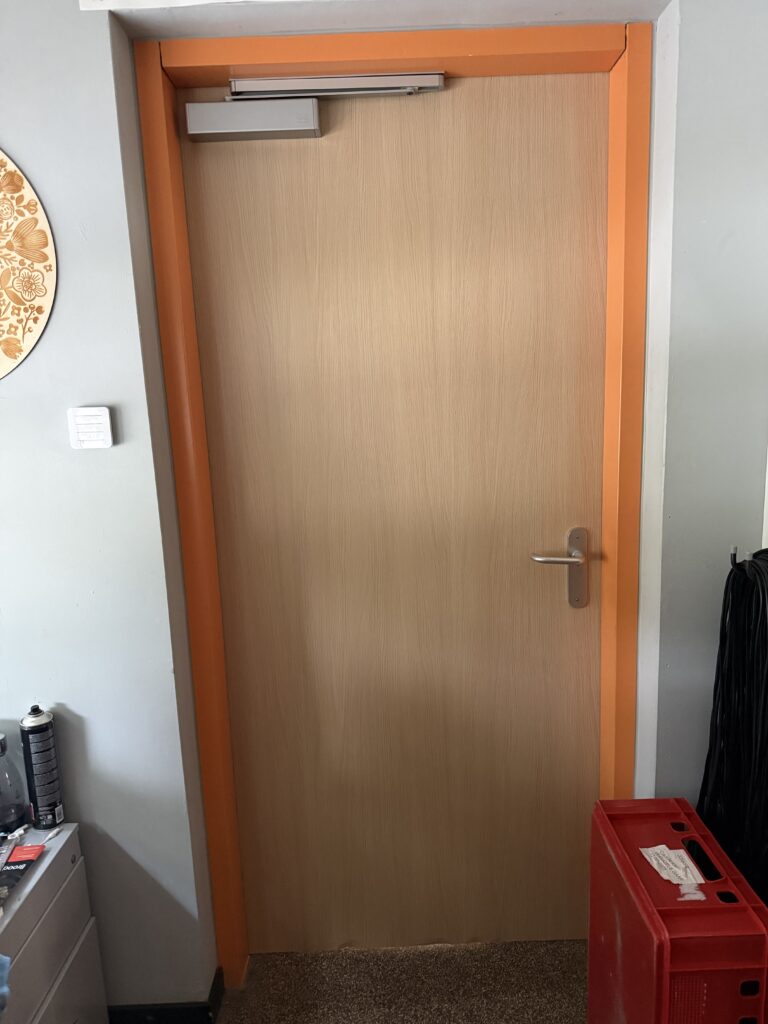 Deur gewrapt in lichte houtlook bij het Coornhert Lyceum