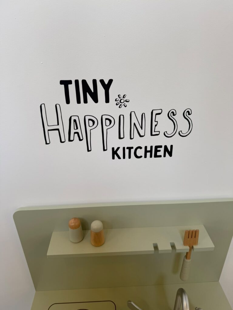 Wandbelettering Tiny Happiness Kitchen bij Happyness Café in Haarlem