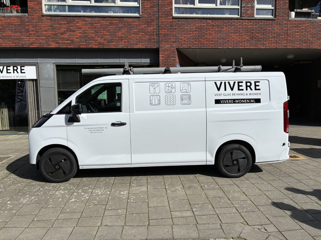 Beletterde bedrijfsbus van Vivere in Haarlem met logo en producticonen op de zijkant