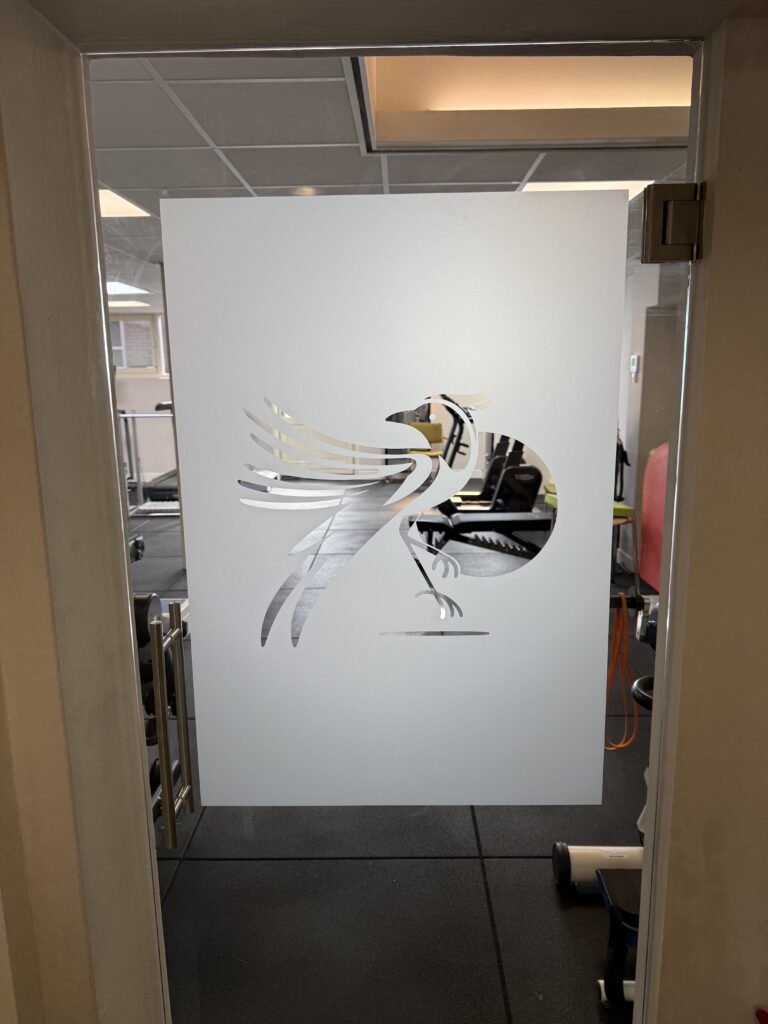 Glazen deur voorzien van melkglasfolie met uitgesneden vogelbeeldmerk