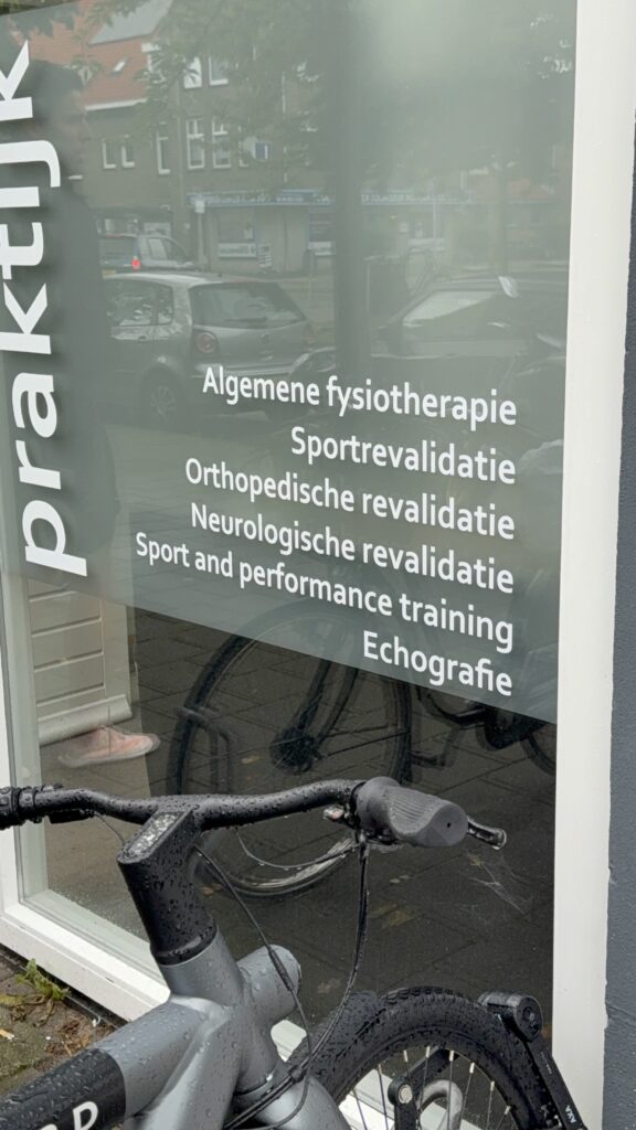 Raam van Fysiotherapie Eksterlaan met witte belettering van de verschillende behandelingen