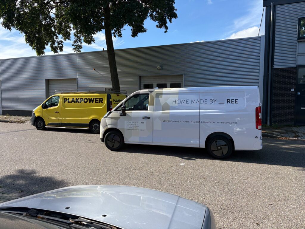 Andere zijde van de bedrijfswagen van Home Made by Ree met beige geometrische wrap en zwarte bedrijfsbelettering.