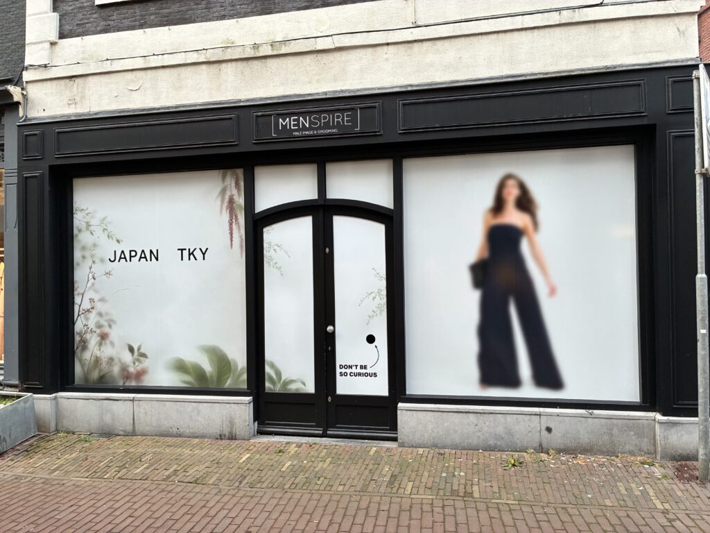 oorzijde van Japan TKY in Haarlem met bedrukte raamfolie, botanische details en een afbeelding van een model.